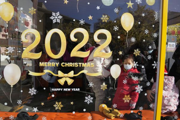 A child wearing a mask looks out from a window promoting the 2022 Christmas holiday at a mall in Beijing, China, Saturday, 25 December 2021. A child wearing a mask looks out from a window promoting the 2022 Christmas holiday at a mall in Beijing, China, Saturday, 25 December 2021. - Sputnik International