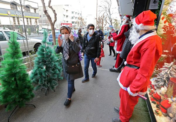 A man dressed as Santa greets Iranians as they walk past a shop selling Christmas decorations in the capital Tehran on 24 December 2021. A man dressed as Santa greets Iranians as they walk past a shop selling Christmas decorations in the capital Tehran on 24 December 2021. - Sputnik International