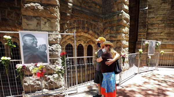 Members of the public pause after placing flowers in memory of Archbishop Desmond Tutu outside St Georges Cathedral in Cape Town, South Africa, December 26, 2021. - Sputnik International