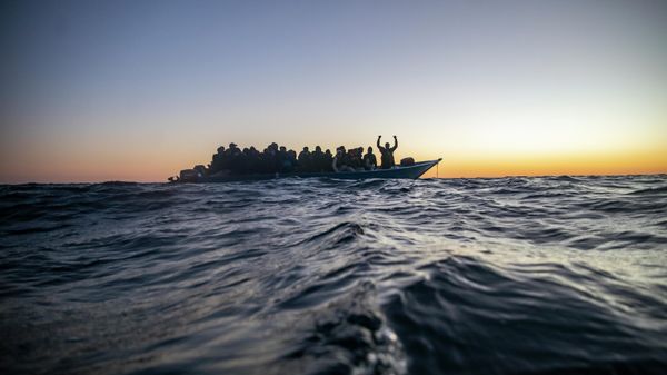 Migrants and refugees of various African nationalities wait for assistance aboard an overcrowded wooden boat in the Mediterranean Sea 122 miles off the coast of Libya as aid workers on the Spanish search and rescue vessel Open Arms approach on Feb. 12, 2021. - Sputnik International