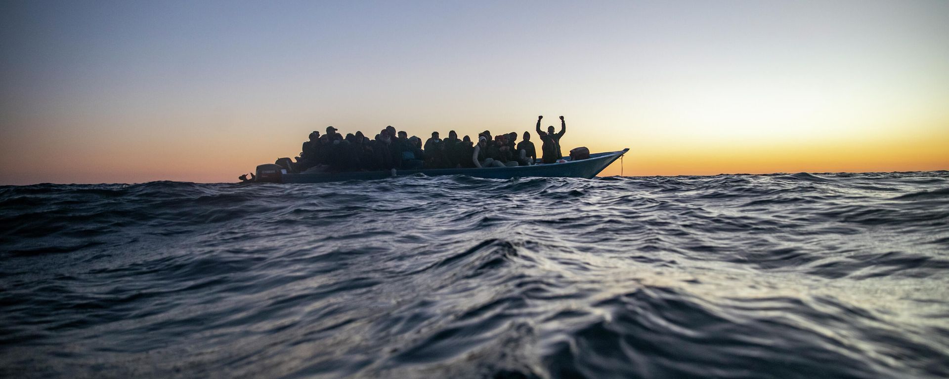 Migrants and refugees of various African nationalities wait for assistance aboard an overcrowded wooden boat in the Mediterranean Sea 122 miles off the coast of Libya as aid workers on the Spanish search and rescue vessel Open Arms approach on Feb. 12, 2021. Migrants and refugees of various African nationalities wait for assistance aboard an overcrowded wooden boat in the Mediterranean Sea 122 miles off the coast of Libya as aid workers on the Spanish search and rescue vessel Open Arms approach on Feb. 12, 2021. - Sputnik International, 1920, 26.12.2021