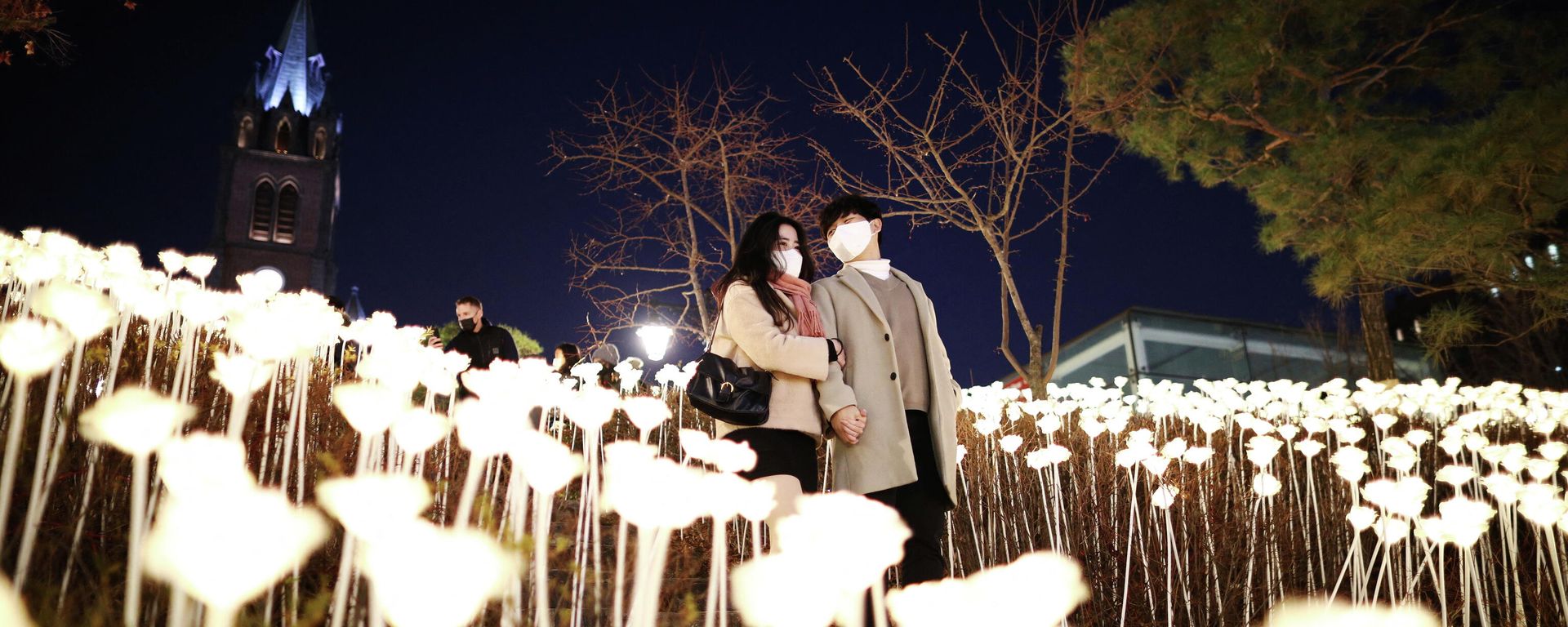 A couple wearing masks to prevent contracting the coronavirus disease (COVID-19) enjoys a Christmas illumination at Myeongdong Cathedral in Seoul, South Korea, December 23, 2021 A couple wearing masks to prevent contracting the coronavirus disease (COVID-19) enjoys a Christmas illumination at Myeongdong Cathedral in Seoul, South Korea, December 23, 2021 - Sputnik International, 1920, 27.12.2021