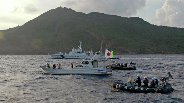 A Japanese Coast Guard boat and vessel sail alongside Japanese activists' fishing boat, not in photo, warning the activists away from a group of disputed islands called Senkaku by Japan and Diaoyu by China on Aug. 18, 2013 - Sputnik International