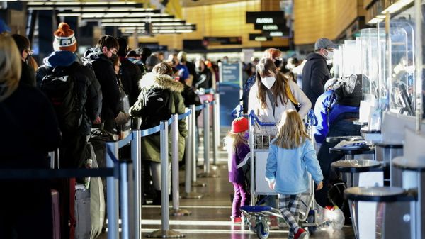A family works through check-in at Alaska Airlines ticketing after dozens of flights were listed as cancelled or delayed at Seattle-Tacoma International Airport (Sea-Tac) in Seattle, Washington, U.S. December 27, 2021. - Sputnik International