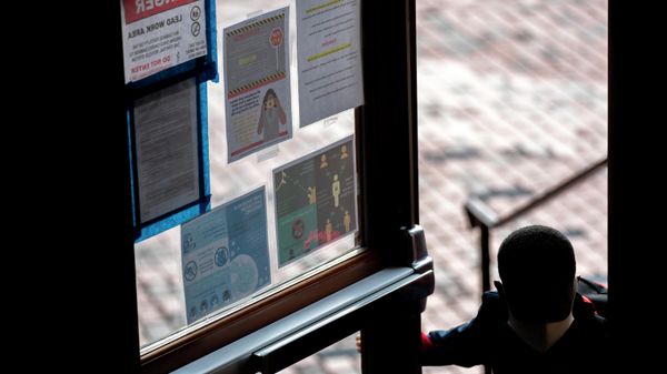 In this Friday, Sept. 18, 2020, photo social distancing information and health warnings are posted on the window of the main door as a student arrives at Meridien Public Charter School, in Washington. - Sputnik International