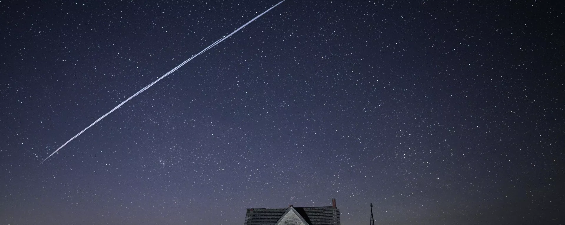 In this photo made with a long exposure, a string of SpaceX StarLink satellites passes over an old stone house near Florence, Kan., on Thursday, May 6, 2021. - Sputnik International, 1920, 17.10.2026