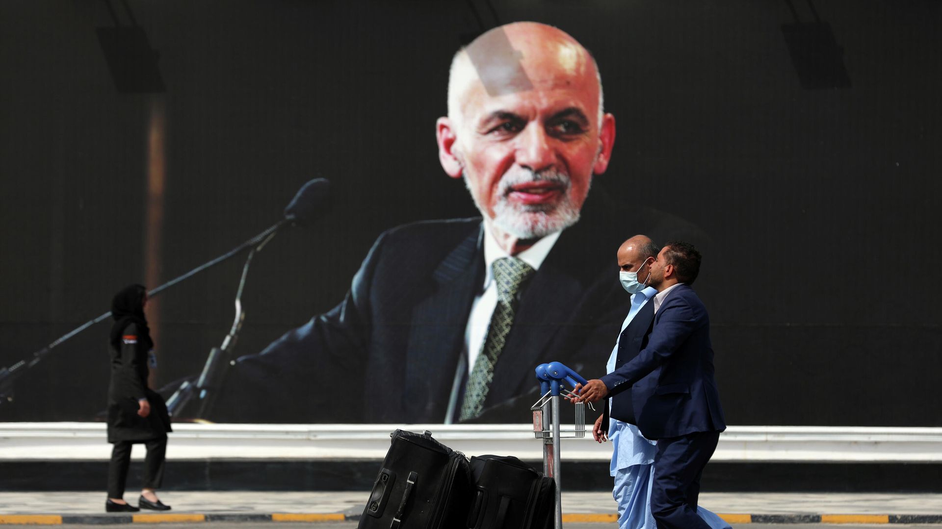 Passengers walk to the departures terminal of Hamid Karzai International Airport in Kabul, Afghanistan, on Saturday, Aug. 14, 2021, past a mural of President Ashraf Ghani, as the Taliban offensive encircled the capital. Passengers walk to the departures terminal of Hamid Karzai International Airport in Kabul, Afghanistan, on Saturday, Aug. 14, 2021, past a mural of President Ashraf Ghani, as the Taliban offensive encircled the capital. - Sputnik International, 1920, 31.12.2021