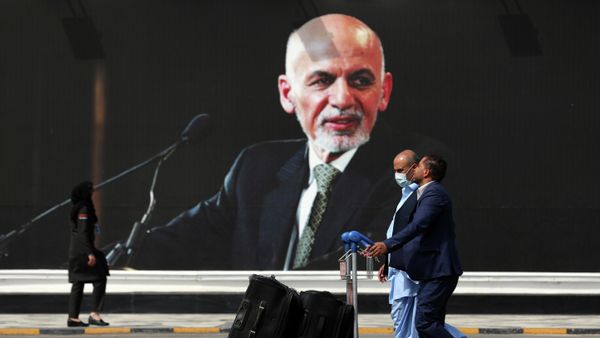 Passengers walk to the departures terminal of Hamid Karzai International Airport in Kabul, Afghanistan, on Saturday, Aug. 14, 2021, past a mural of President Ashraf Ghani, as the Taliban offensive encircled the capital.  - Sputnik International