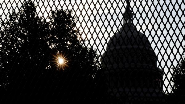 FILE PHOTO: The sun rises behind the U.S. Capitol, surrounded by a security fence ahead of an expected rally Saturday in support of the Jan. 6 defendants in Washington, U.S. September 16, 2021.  REUTERS/Jonathan Ernst/File Photo - Sputnik International