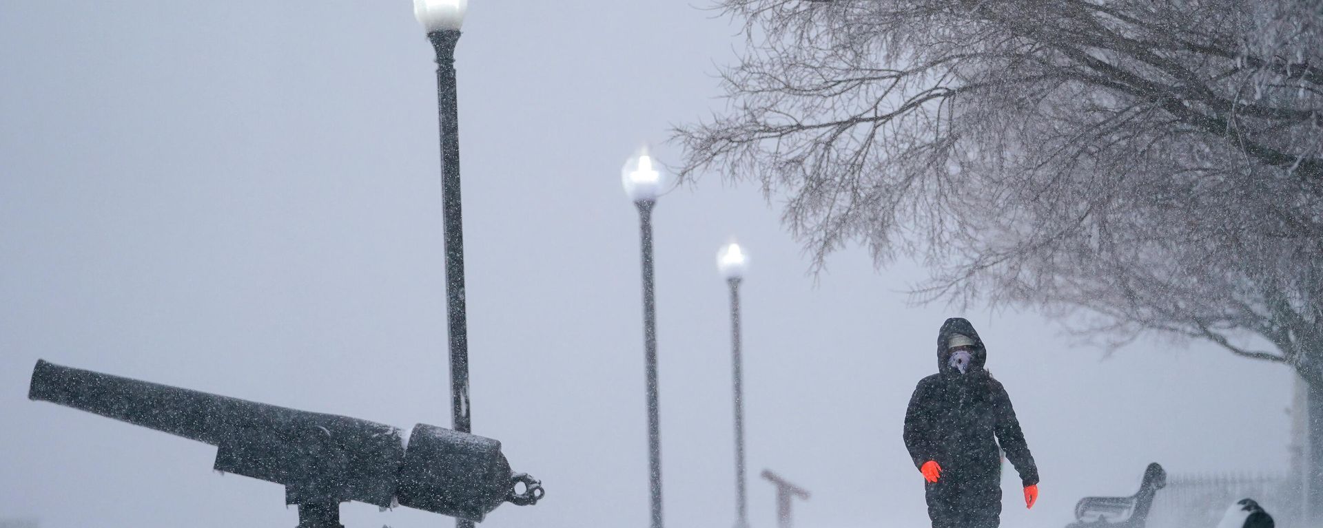 Snow blows sideways in gusty wind as Karla Rivas strolls at Federal Hill Park, Monday, Jan. 3, 2022, in Baltimore. Rivas, who is originally from Miami, said this was her first snow storm. Snow blows sideways in gusty wind as Karla Rivas strolls at Federal Hill Park, Monday, Jan. 3, 2022, in Baltimore. Rivas, who is originally from Miami, said this was her first snow storm. - Sputnik International, 1920, 03.01.2022