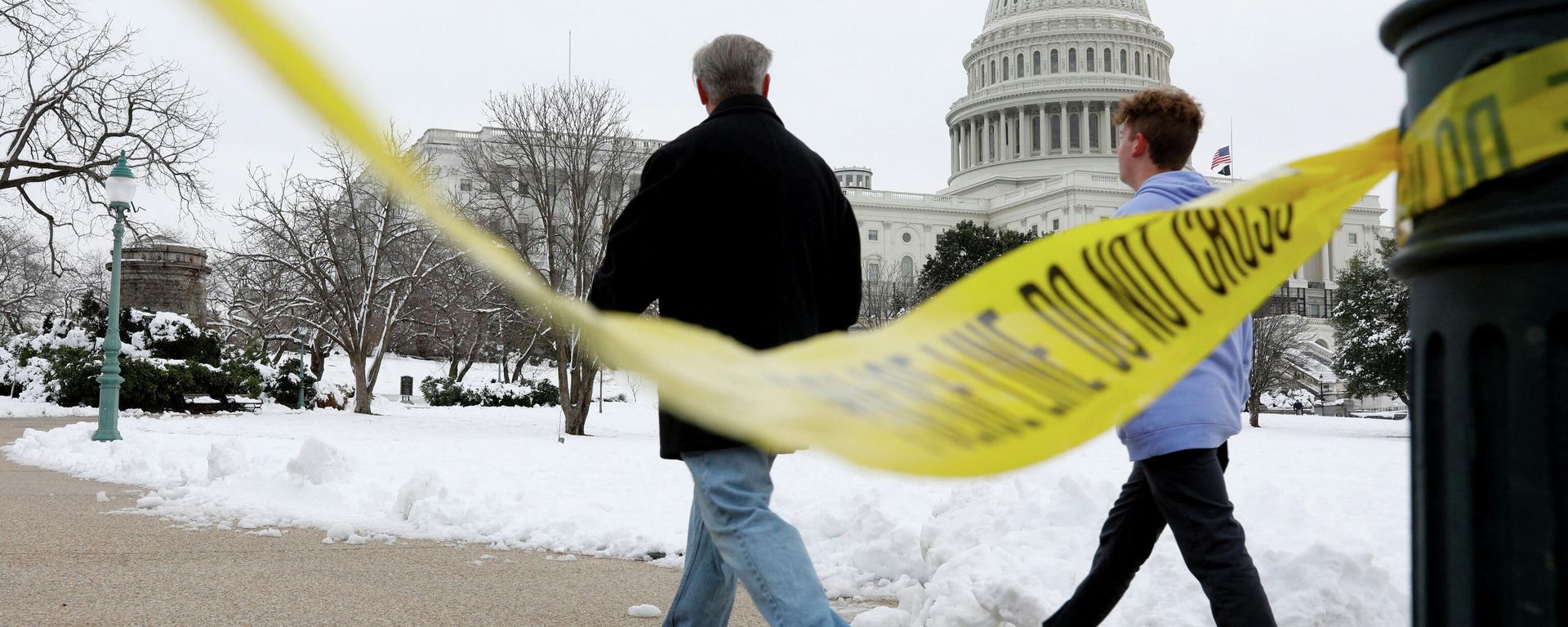 Visitors walk beside yellow police tape on the eve of the first anniversary of the January 6, 2021 attack on the U.S. Capitol, on Capitol Hill in Washington Visitors walk beside yellow police tape on the eve of the first anniversary of the January 6, 2021 attack on the U.S. Capitol, on Capitol Hill in Washington - Sputnik International, 1920, 05.01.2022