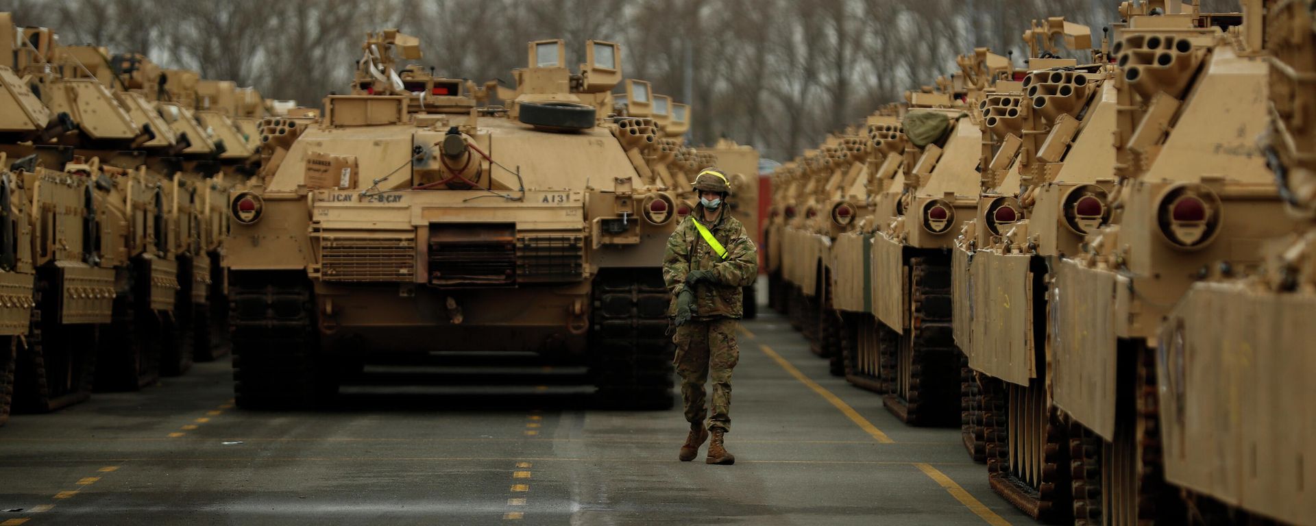 A U.S. soldier walks past parked armoured vehicles and tanks of the 1st Armored Brigade Combat Team and 1st Calvary Division, based out of Fort Hood, Texas, as they are unloaded at the port of Antwerp, Belgium, Monday, Nov. 16, 2020. The U.S. military vehicles are on their way to Eastern Europe to take part in the Atlantic Resolve military exercises, in which American troops train together with NATO partners to help ensure stability in Europe. - Sputnik International, 1920, 25.05.2025