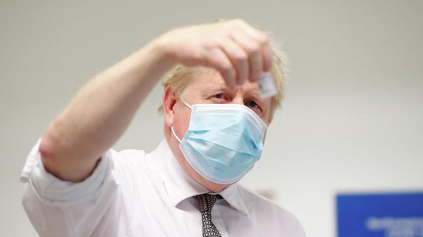 Britain's Prime Minister Boris Johnson checks a coronavirus disease (COVID-19) vaccine during a visit to a vaccine centre in Northampton - Sputnik International