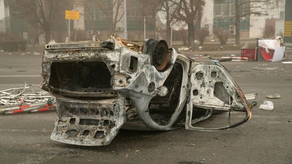 A burned-out automobile is seen on a square near an administrative quarter in central Almaty on January 6, 2022 - Sputnik International
