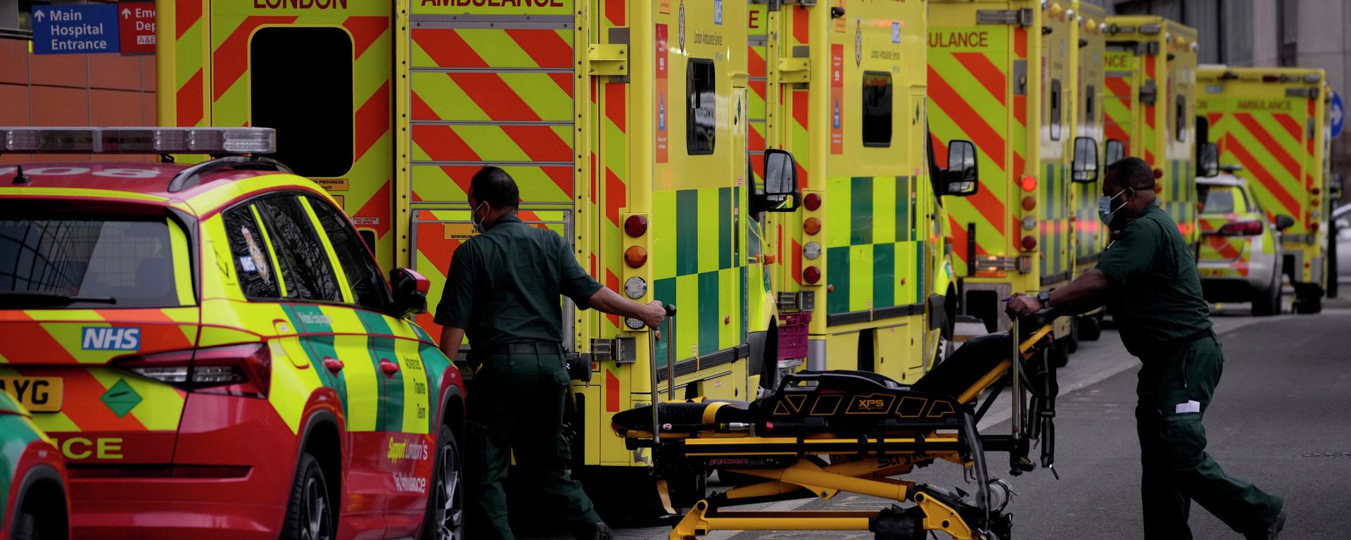Paramedics push a trolley next to a line of ambulances outside the Royal London Hospital in the Whitechapel area of east London, Thursday, Jan. 6, 2022 Paramedics push a trolley next to a line of ambulances outside the Royal London Hospital in the Whitechapel area of east London, Thursday, Jan. 6, 2022 - Sputnik International, 1920, 11.01.2022