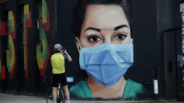 A cyclist takes a picture of a recently painted mural by professional street artist David Speed and the Graffiti Life collective to show appreciation for the people who work in the NHS (National Health Service), in east London, Thursday, April 23, 2020 - Sputnik International