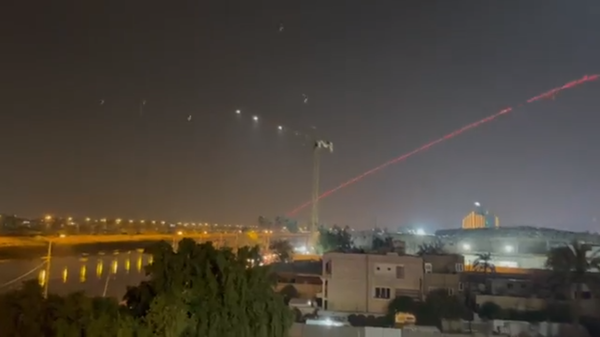 C-RAM air defenses streak across the skies over Baghdad as they intercept rockets launched at the US embassy inside the Green Zone on January 13, 2022. - Sputnik International