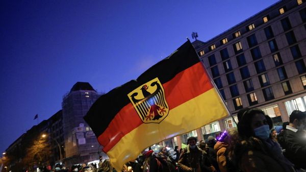 A person carries a German flag during a demonstration against coronavirus disease (COVID-19) measures, in Hamburg, Germany 18 December 2021 - Sputnik International