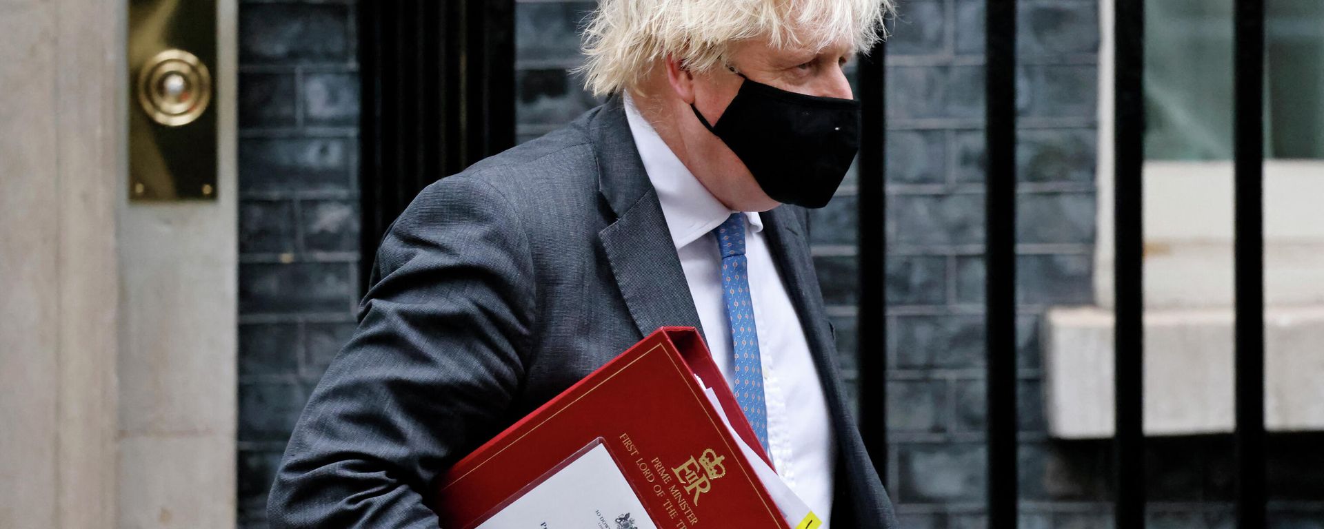 Britain's Prime Minister Boris Johnson, wearing a face covering to stop the spread of coronavirus, carries his notes in a ministerial folder as he leaves from 10 Downing Street in central London on December 15, 2021, to take part in the weekly session of Prime Minister Questions (PMQs) at the House of Commons Britain's Prime Minister Boris Johnson, wearing a face covering to stop the spread of coronavirus, carries his notes in a ministerial folder as he leaves from 10 Downing Street in central London on December 15, 2021, to take part in the weekly session of Prime Minister Questions (PMQs) at the House of Commons - Sputnik International, 1920, 16.01.2022