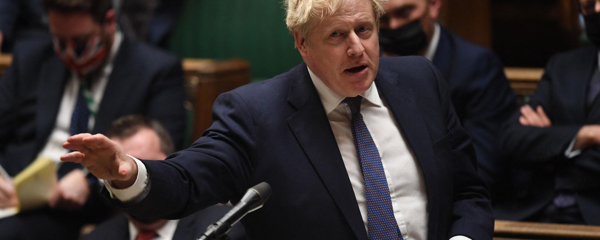 A handout photograph released by the UK Parliament shows Britain's Prime Minister Boris Johnson gesturing during the Prime Minister’s COVID-19 Update in the House of Commons in London on December 15, 2021 A handout photograph released by the UK Parliament shows Britain's Prime Minister Boris Johnson gesturing during the Prime Minister’s COVID-19 Update in the House of Commons in London on December 15, 2021 - Sputnik International, 1920, 19.01.2022
