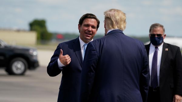 President Donald Trump speaks with Florida Gov. Ron DeSantis as he arrives at Southwest Florida International Airport, Friday, Oct. 16, 2020, in Fort Myers, Fla. - Sputnik International