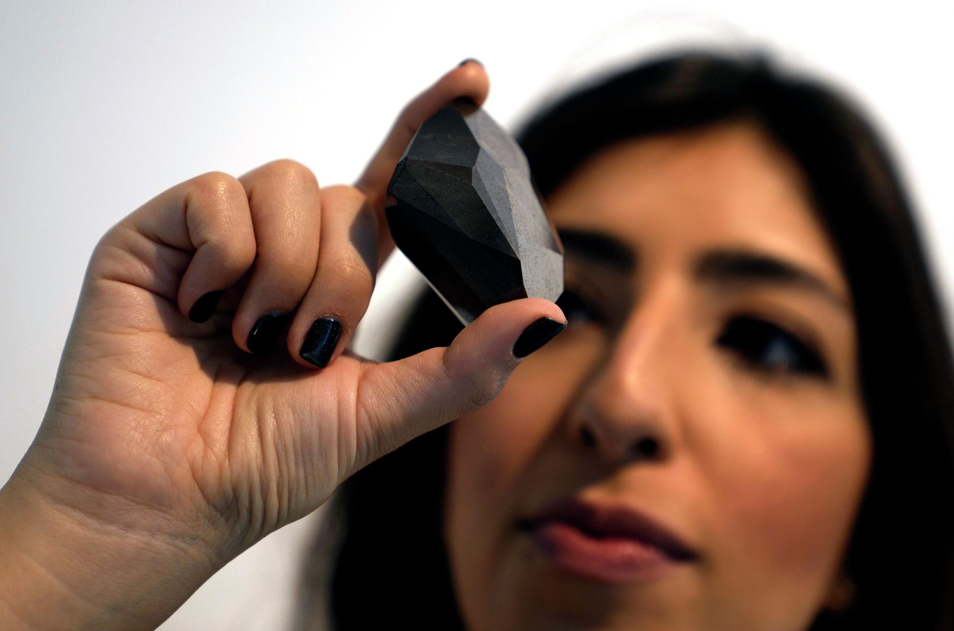 An employee of Sotheby's Dubai presents a 555.55 Carat Black Diamond The Enigma to be auctioned at Sotheby's Dubai gallery, in Dubai, United Arab Emirates, Monday, Jan. 17, 2022. An employee of Sotheby's Dubai presents a 555.55 Carat Black Diamond The Enigma to be auctioned at Sotheby's Dubai gallery, in Dubai, United Arab Emirates, Monday, Jan. 17, 2022. - Sputnik International, 1920, 18.01.2022