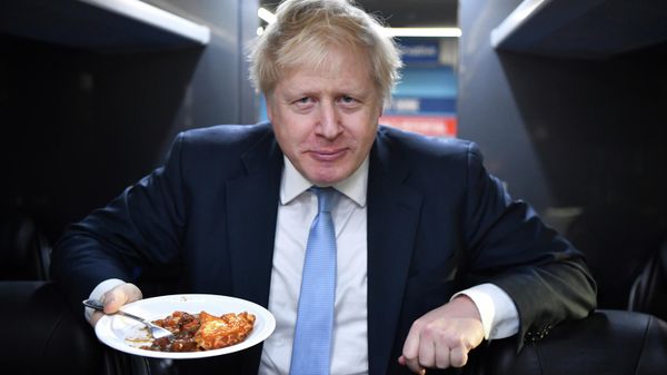 Britain's Prime Minister Boris Johnson eats a portion of pie aboard the Conservative Party campaign bus after a visit to the Red Olive catering company in Derby, central England Wednesday Dec. 11, 2019. Britain's Prime Minister Boris Johnson eats a portion of pie aboard the Conservative Party campaign bus after a visit to the Red Olive catering company in Derby, central England Wednesday Dec. 11, 2019. - Sputnik International
