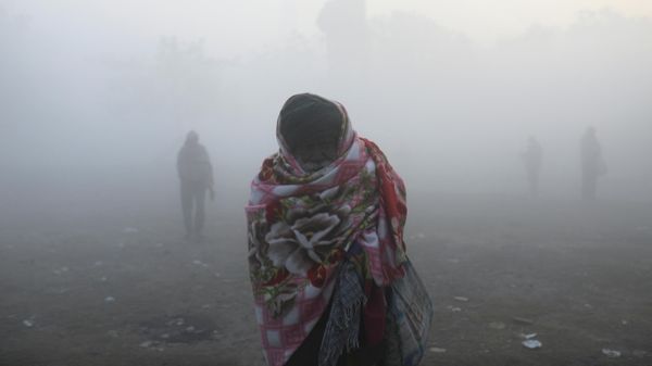 A man covered with a quilt stands on the banks of the Yamuna river on a cold winter morning in New Delhi, India, December 22, 2021 - Sputnik International
