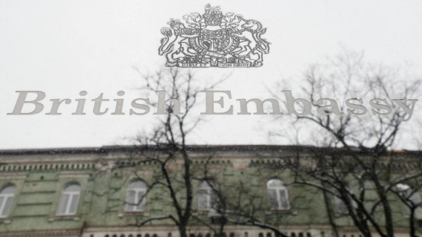 A building, which is located on the opposite side of a street, is reflected in a sign hanging on the facade of the British Embassy in Kyiv, Ukraine January 24, 2022. The British Embassy in Ukraine said some staff and dependants were being withdrawn from Kyiv amid tensions between Russia and the West over Ukraine. REUTERS/Gleb Garanich - Sputnik International