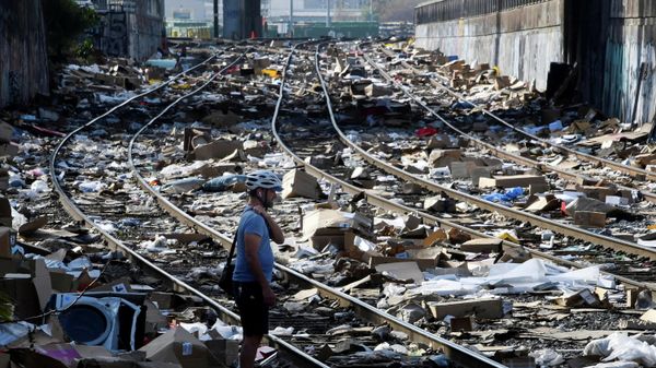 Local resident Luke Mines takes photos as he looks at the mess on railway tracks littered with the remains of items stolen from passing freight trains, in Los Angeles. California. U.S., January 14,2022.  - Sputnik International