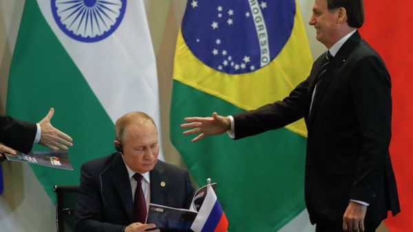 Brazil's President Jair Bolsonaro (R) and Russian President Vladimir Putin (L) attend to  a meeting with members of the Business Council and management of the New Development Bank during the BRICS Summit in Brasilia, November 14, 2019 - Sputnik International