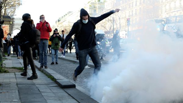 A demonstrator kicks a tear gas grenade during a protest on the Champs-Elysees avenue, Saturday, Feb.12, 2022 in Paris.  - Sputnik International
