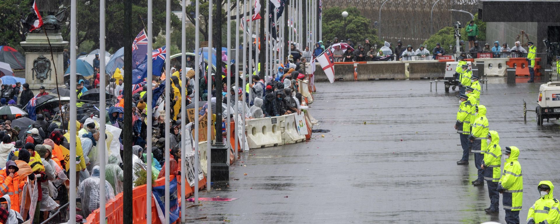 Police stand guard in front of protestors rallying against coronavirus disease (COVID-19) vaccination mandates despite the rain, near the parliament building in Wellington, New Zealand - Sputnik International, 1920, 13.02.2022