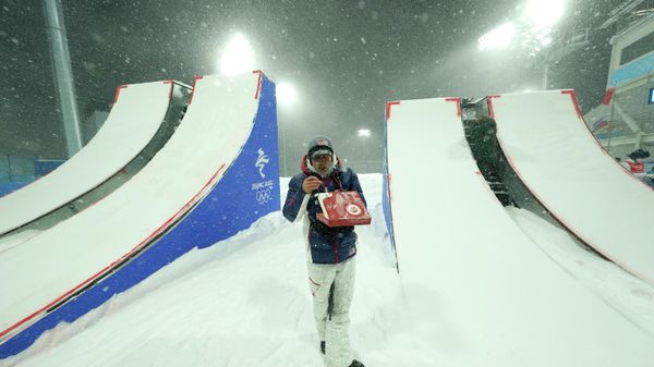 A United States team member has some pizza while waiting out in the snow as the women's aerials qualification has been delayed due to a weather condition at the 2022 Winter Olympics, Sunday, Feb. 13, 2022, in Zhangjiakou, China. - Sputnik International