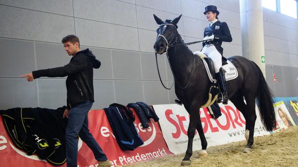 Bayern Munich's midfielder Thomas Mueller (L) gestures next to his wife Lisa Mueller who sits on her twelve year old horse 'Dave' during the Munich Indoors 2015 equestrian tournament on November 8, 2015, in Munich, southern Germany - Sputnik International