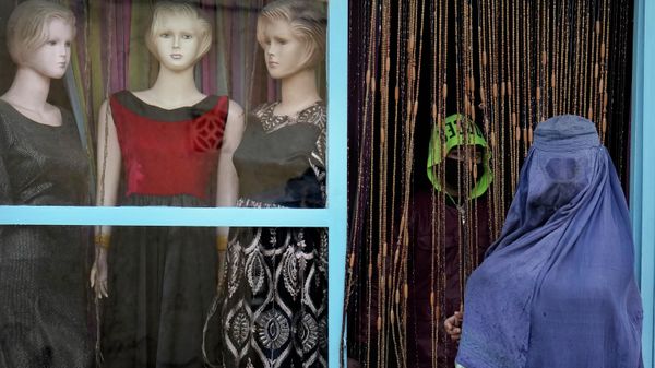 An Afghan woman wearing a burka enters a tailor's shop in Kabul, Afghanistan, Tuesday, Feb. 8, 2022. - Sputnik International