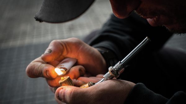 A drug addict lights an improvised pipe in Crackolandia, a place where drug addicts gather to smoke crack, in downtown Sao Paulo Brazil on January 11, 2013 - Sputnik International