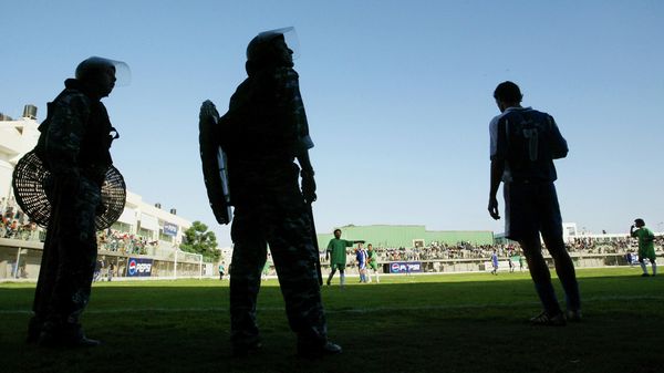 Palestinian riot police officers stand guard at the side of the field next to players during the annual Gaza Cup football match at the Palestine Football Stadium  in Gaza City, Sunday, August 1, 2004 - Sputnik International
