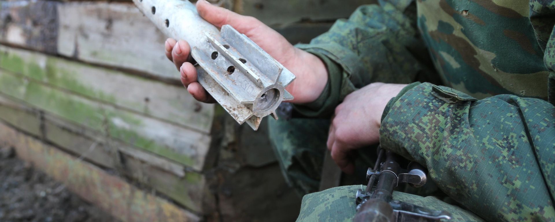 Donbass militiaman holds up piece of shell fired on his comrades' position by Kiev forces in Western Donetsk. 15 February 2022. Donbass militiaman holds up piece of shell fired on his comrades' position by Kiev forces in Western Donetsk. 15 February 2022. - Sputnik International, 1920, 18.02.2022