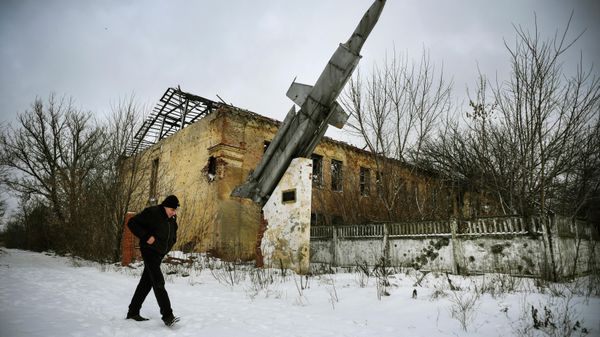 A man walks past a destroyed building of a former military installation in the village of Vesyoloye, suburb of Donetsk, capital of a self-proclaimed Donetsk People's Republic (DPR) in eastern Ukraine - Sputnik International