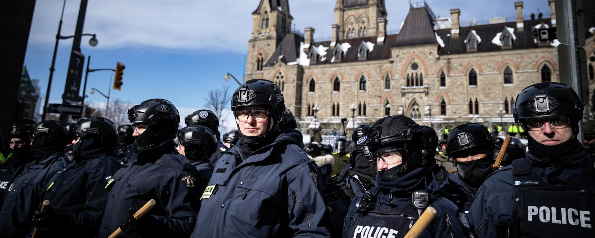 Police block protesters after taking the main street where trucks are parked in Ottawa near Parliament hill on Saturday, Feb. 19, 2022. Police resumed pushing back protesters on Saturday after arresting more than 100 and towing away vehicles in Canada’s besieged capital, and scores of trucks left under the pressure, raising authorities’ hopes for an end to the three-week protest against the country’s COVID-19 restrictions. (AP Photo/Robert Bumsted) Police block protesters after taking the main street where trucks are parked in Ottawa near Parliament hill on Saturday, Feb. 19, 2022. Police resumed pushing back protesters on Saturday after arresting more than 100 and towing away vehicles in Canada’s besieged capital, and scores of trucks left under the pressure, raising authorities’ hopes for an end to the three-week protest against the country’s COVID-19 restrictions. (AP Photo/Robert Bumsted) - Sputnik International, 1920, 20.02.2022