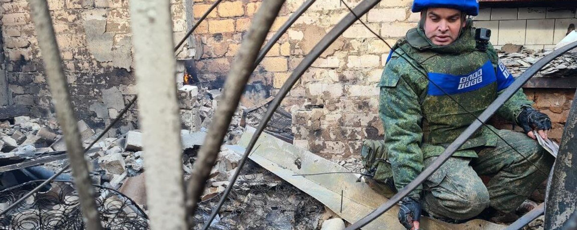 A representative of the Joint Centre for Control and Coordination of the Ceasefire Regime (JCCC) of the LPR near the house that was hit by an artillery strike by the Ukrainian Armed Forces on the village of Pionerskoye in the LPR. File photo. - Sputnik International, 1920, 06.01.2023