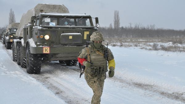 A service member of the Ukrainian Armed Forces runs near self-propelled multiple rocket launcher systems during drills in the Kherson region, Ukraine, in this handout picture released February 1, 2022.  - Sputnik International