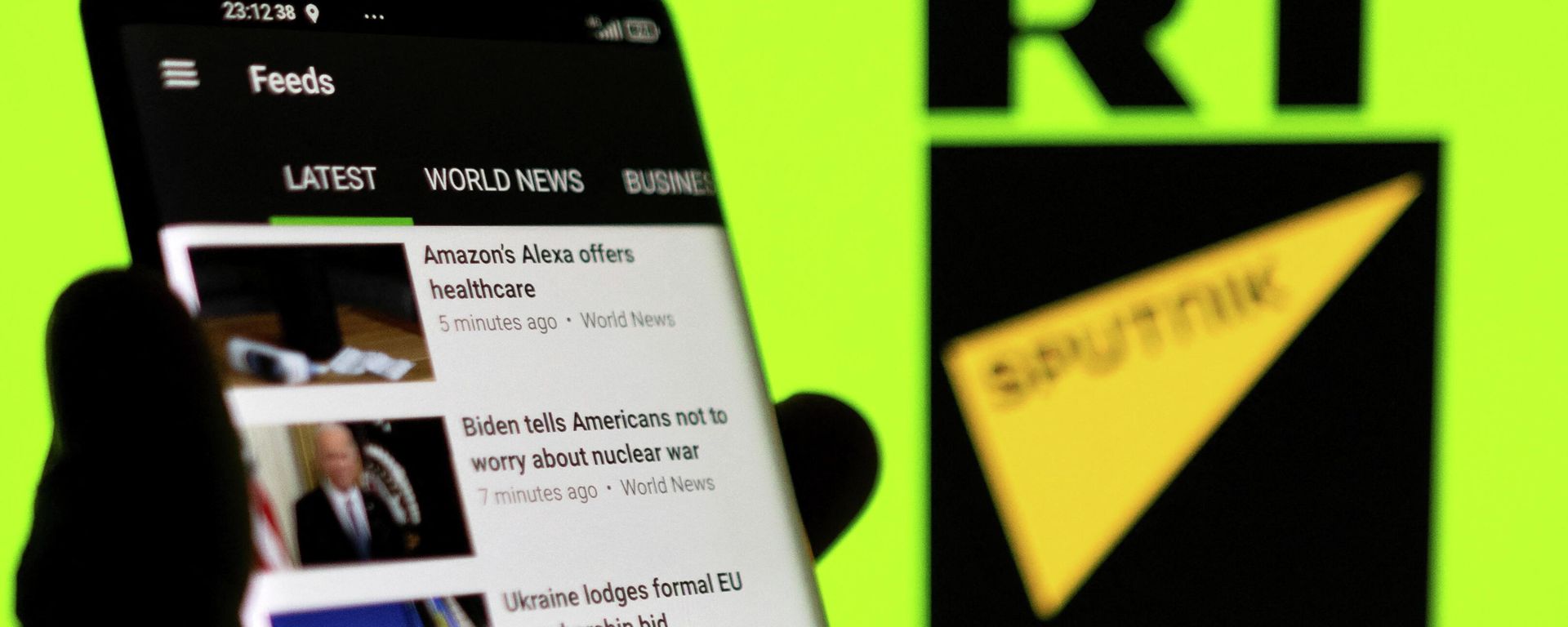 RT app is seen on a smartphone in front of RT and Sputnik logo in this illustration taken February 28, 2022 - Sputnik International, 1920, 02.03.2022