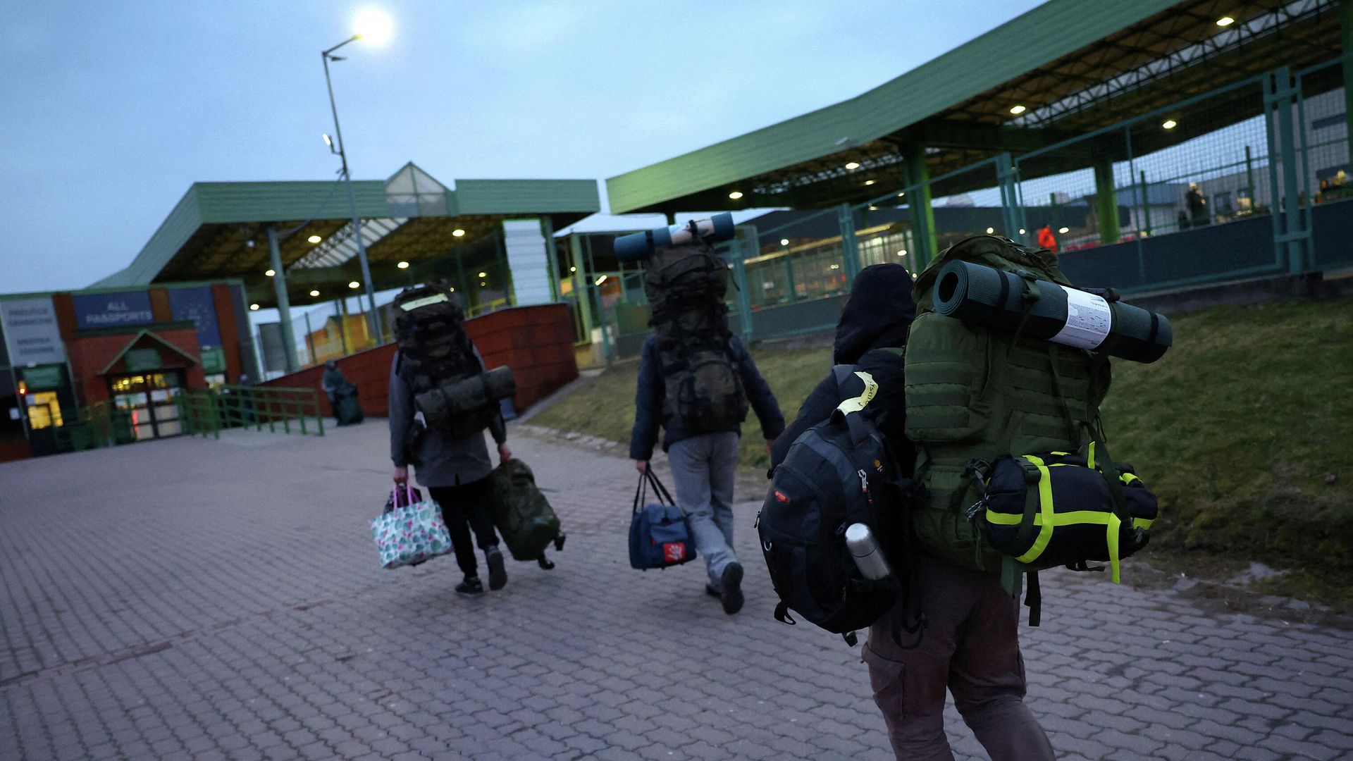 Ukrainian men carry their equipment towards the border as they return to Ukraine to fight the Russian forces, at the border checkpoint in Medyka, Poland, March 2, 2022 - Sputnik International, 1920, 03.03.2022