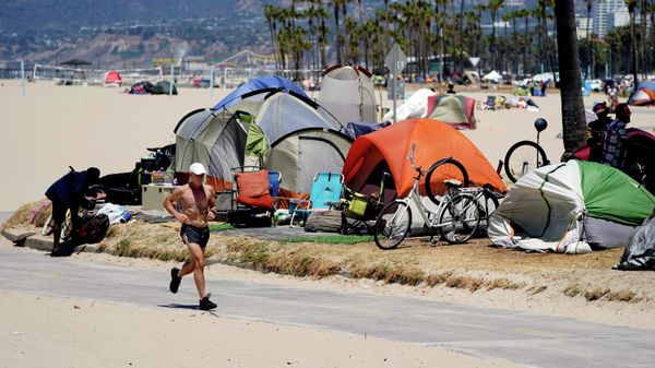  In this June 8, 2021, file photo, a jogger runs past a homeless encampment in the Venice Beach section of Los Angeles. California Gov. Newsom on Thursday, Sept 16, 2021, approved two measures to slice through local zoning ordinances as the most populous state struggles with soaring home prices, an affordable housing shortage and stubborn homelessness. Newson signed the most prominent legislation despite nearly 250 cities objecting that it will, by design, undermine local planning and control. - Sputnik International