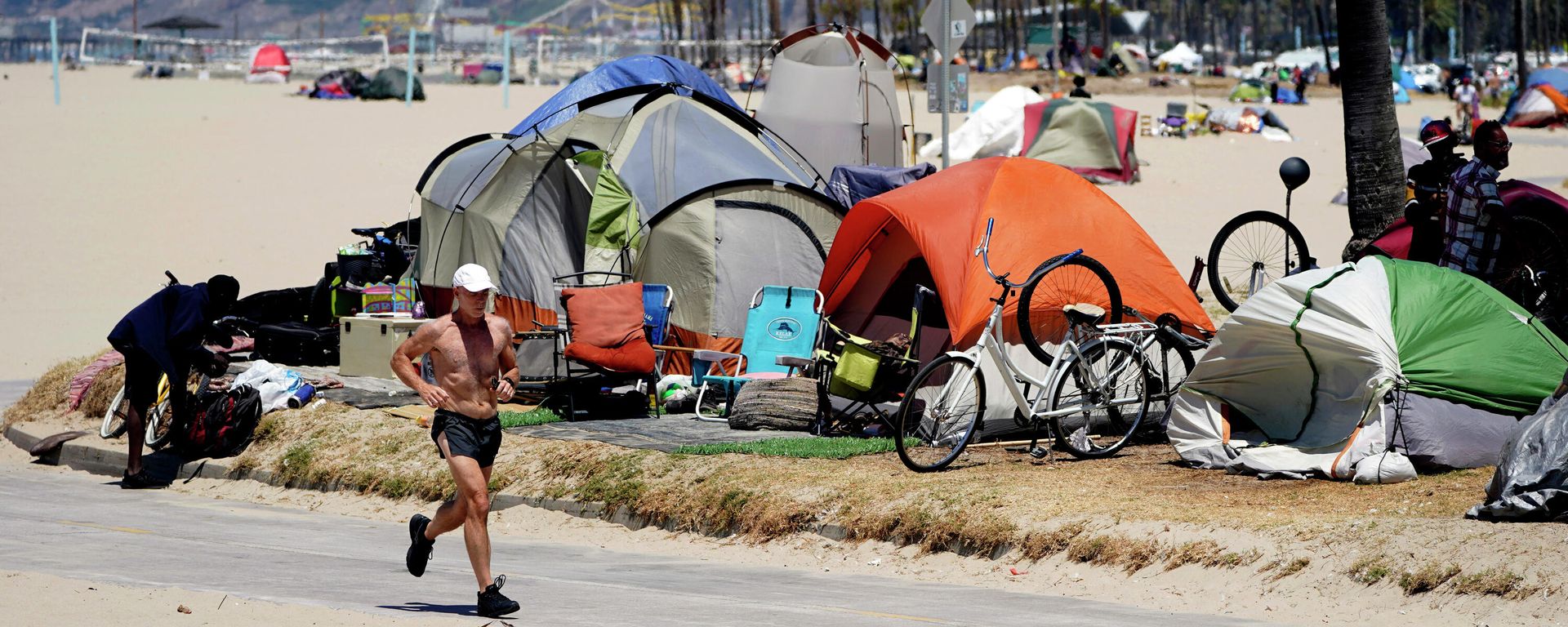  In this June 8, 2021, file photo, a jogger runs past a homeless encampment in the Venice Beach section of Los Angeles. - Sputnik International, 1920, 30.06.2023