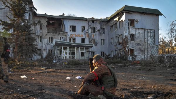 A fighter of the People's Militia of the DPR near the building of the city hospital, which was destroyed as a result of shelling in Volnovakha. - Sputnik International