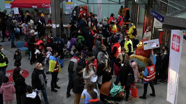 Volunteers help Ukrainian refugees in a reception hall of the main railway station in Munich, southern Germany, on March 12, 2022 - Sputnik International