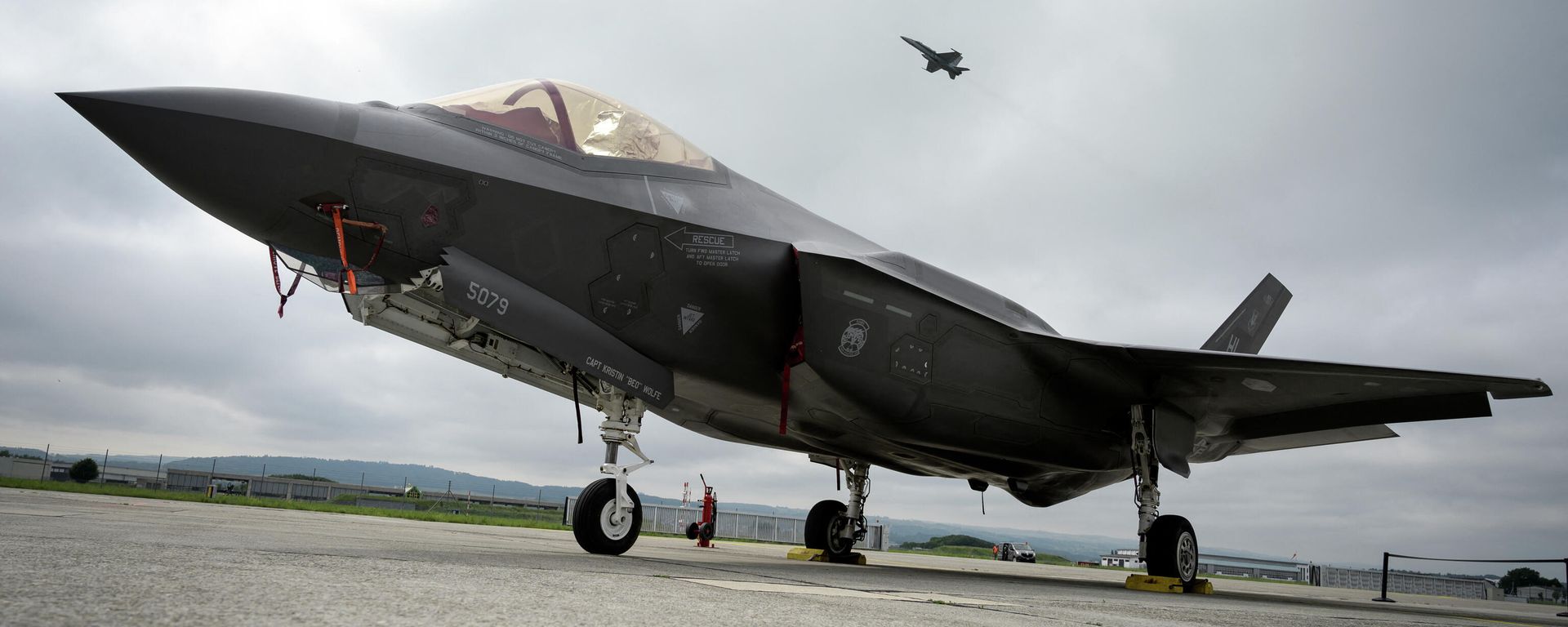 This file photo taken on June 7, 2019 shows a Lockheed Martin F-35 Lightning II fighter jet parked on the tarmac at the Payerne Air Base as a Boeing McDonnell Douglas F/A-18 Hornet takes off in the background, during flight and ground tests. This file photo taken on June 7, 2019 shows a Lockheed Martin F-35 Lightning II fighter jet parked on the tarmac at the Payerne Air Base as a Boeing McDonnell Douglas F/A-18 Hornet takes off in the background, during flight and ground tests. - Sputnik International, 1920, 14.03.2022